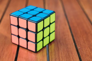 Ahşap arka planda Rubiks küpü. Kapatın. Uzay afişini kopyala. Ahşap arka planda renkli bir oyuncak.
