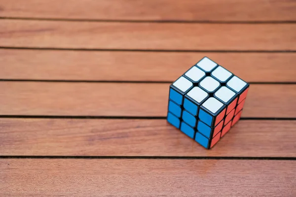 Кубик Рубика на деревянном фоне. Закрывай. Копировать космический баннер. Красочная игрушка на деревянном фоне . — стоковое фото