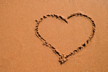 Kalp kuma, deniz kenarına çizilmiş. Altın kumsal kapanışı, yaz tatili sınır çerçevesi konsepti.