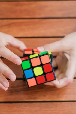 Rubiks küpünü tutan ve masada oynayan sevimli çocuk portresi. Rubiks küpü çocukların elinde. Pankart.