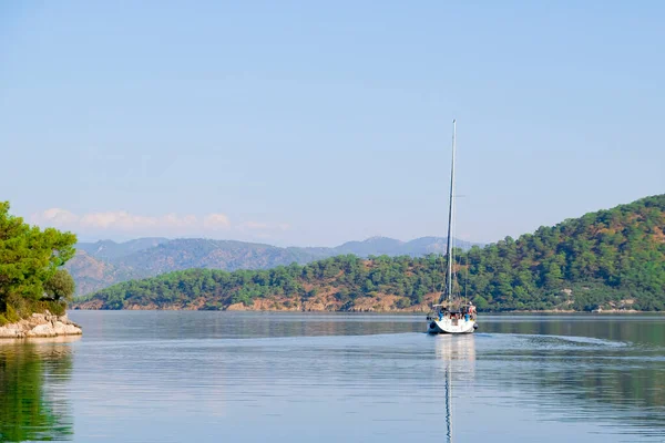 Racing yacht in the sea on blue sky background. Peaceful seascape. Beautiful blue sky over calm sea.