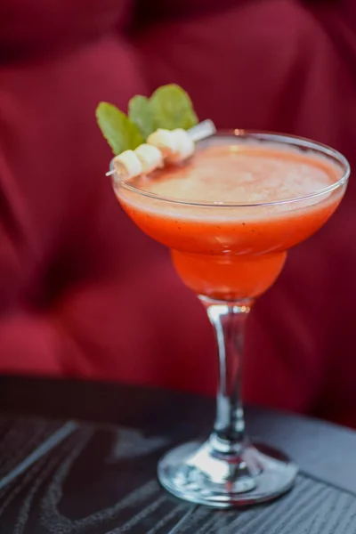 Cóctel de alcohol rojo de verano frío con hielo una copa Martini alta sobre fondo borroso de restaurante o cafetería . — Foto de Stock