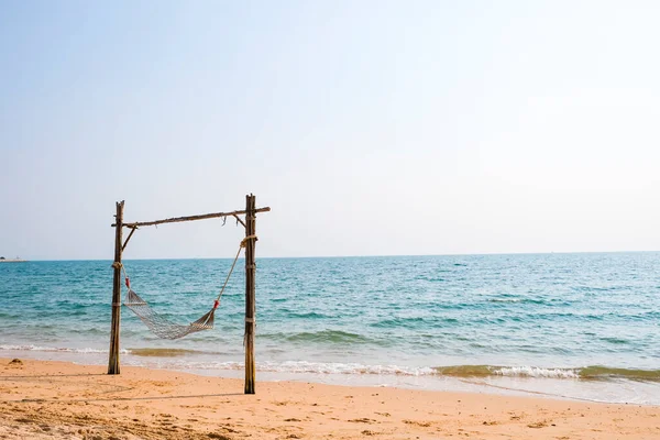 Ensam romantisk mysig hängmatta på den tropiska stranden vid havet. Lugnt och fridfullt kustlandskap. — Stockfoto