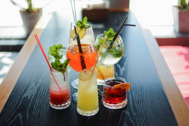 Yaz mevsiminde bardaki ahşap masada birkaç kokteyl içilir. Yaz mevsimi alkollü içecekler bir barda ya da restoranda.