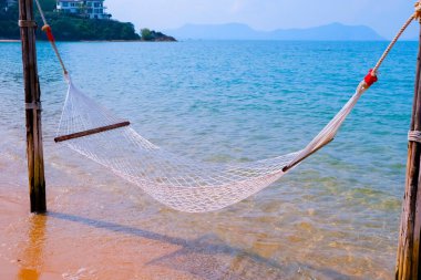 Deniz kenarındaki tropikal sahilde samimi bir hamak. Huzurlu deniz manzarası. Rahatla, seyahat konsepti, seyahat.
