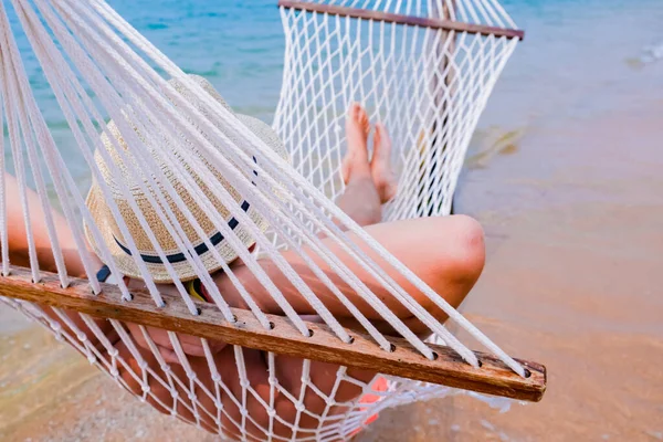 Nahaufnahme eines Jungen, der in einer Hängematte am Strand liegt. Gemütliche Hängematte am tropischen Strand am Meer. — Stockfoto