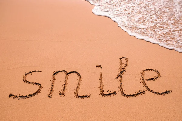 Word Smile Hand Den Sand Mit Einer Meereswelle Geschrieben Nahaufnahme — Stockfoto