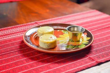 Geleneksel kırmızı masa örtüsünün üzerinde seramik tabakta servis edilen süzme peynirli cheesecake 'ler. Ukrayna mutfağı, Ukrayna konsepti.