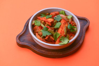 Parlak turuncu arka planda servis edilen bir kasede sebzeli tavuk eti ve nar tohumları. Kopya alanı olan bir pankart tasarla. Yemek fotoğrafçılığı, sağlıklı yemek..