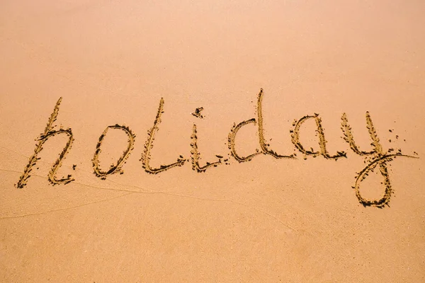 Word Holiday Hand Written Wet Sand Close Sand Texture Beach — Stock Photo, Image