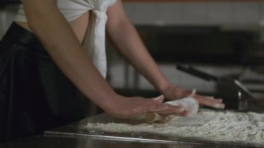 Masada un içinde hamur yoğuran genç ve çekici bir kadın. Seksi kızıl saçlı kızıl saçlı, siyah, seksi diz boyu çoraplı kadın mutfakta..