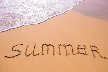 Kelime Yaz eli bir deniz dalgası ile kuma yazılmış. Yazın kumsaldaki kum dokusunu kapat. Tatil, tatil konsepti, boş plaj. Pankart.
