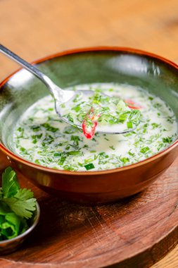 Popüler ilkbahar ve yaz soğuk çorba okroshka. Okroshka kasede, limon ve otlar kırsal ahşap masada. Geleneksel mutfak konsepti, Gürcü, Rus mutfağı.