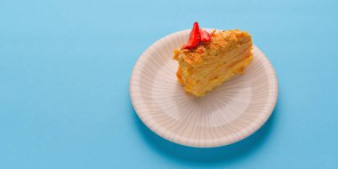 Beyaz tabakta servis edilen süzme peynirli ve çilekli krep. Pastel mavi arka planda çilekli kısa kek. Boşluk afişini kopyala.