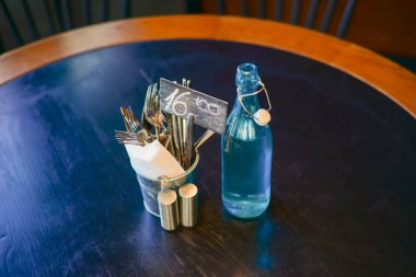 Masaya ayırtılmış tabela. Ahşap bir masada temiz cam su şişesi. Hayat, restoran konseptinde yemek yemek. Kapat..