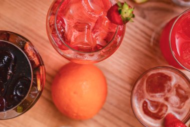 Meyve suyu ve buzlu yaz içecekleri. Kırsal ahşap arka planda farklı bardaklarda yaz içeceklerini tazelemek. Alkol içecekleri konsepti.