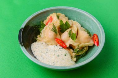 Ukrayna yemeği Vareniki, Ukrayna hamur köftesi, soslu pierogi - beyaz masa örtüsü üzerinde servis edilen geleneksel Ukrayna yemeği.