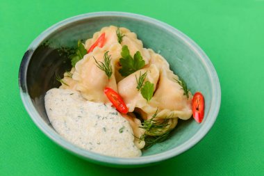 Ukrayna yemeği Vareniki, Ukrayna hamur köftesi, soslu pierogi - beyaz masa örtüsü üzerinde servis edilen geleneksel Ukrayna yemeği.