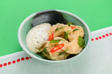 Ukrayna yemeği Vareniki, Ukrayna hamur köftesi, soslu pierogi - beyaz masa örtüsü üzerinde servis edilen geleneksel Ukrayna yemeği.