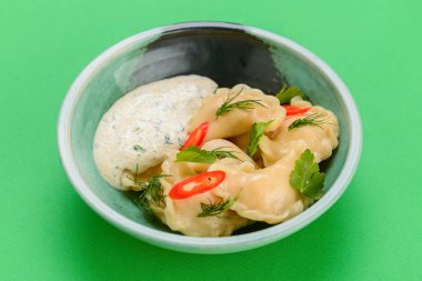 Ukrayna yemeği Vareniki, Ukrayna hamur köftesi, soslu pierogi - beyaz masa örtüsü üzerinde servis edilen geleneksel Ukrayna yemeği.