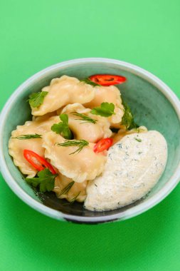 Ukrayna yemeği Vareniki, Ukrayna hamur köftesi, soslu pierogi - beyaz masa örtüsü üzerinde servis edilen geleneksel Ukrayna yemeği.