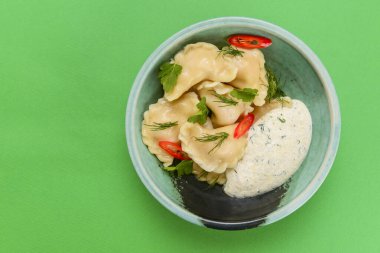 Ukrayna yemeği Vareniki, Ukrayna hamur köftesi, soslu pierogi - beyaz masa örtüsü üzerinde servis edilen geleneksel Ukrayna yemeği.