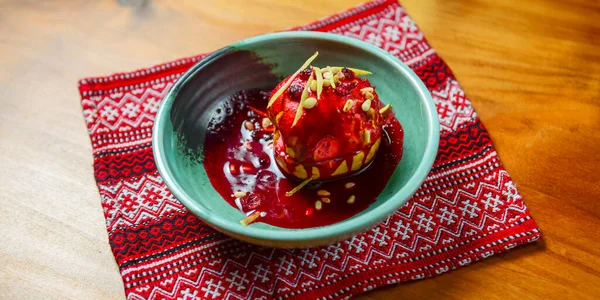 Kuru üzümlü, şekerli ve cevizli nefis bir elma geleneksel Ukrayna kırmızı masa örtüsünün üzerinde servis edilir. Geleneksel tatlı, çay zamanı. Elma şekeri.