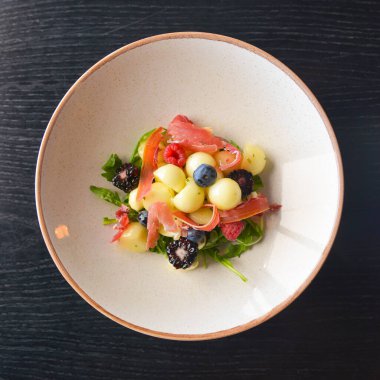 Karışık yaz meyveleri salatası. Mevsimlik yaz salatası, meyve, böğürtlen ve İtalyan jambonlu et. Lezzetli ve organik yemek kavramı.