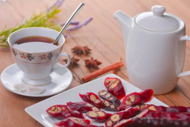 Lezzetli oryantal tatlılar. Kafkasya usulü leziz kilise kilisesi - Gürcü fındık ikramı. Bir bardak çay ve çaydanlıkla servis edilir. Tatlılarla çay zamanı. Geleneksel Gürcü mutfağı.