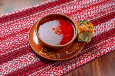 Geleneksel Ukrayna Borsch 'u. Rus vejetaryen kırmızı çorbası. Kırsal ahşap masa arka planında seramik bir kasede. Borş, pancar ve geleneksel kırmızı masa örtüsü..