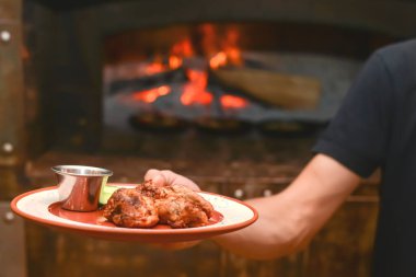 Garson elinde soslu ızgara et ve küçük metal bir kasede sos tutuyor. Restoran fotoğrafçılığı konsepti.