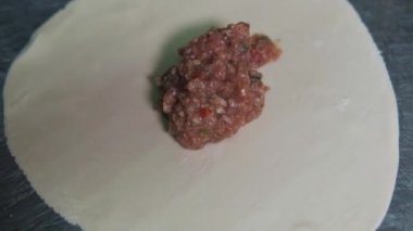 Yemek video konsepti. Aşçı khinkali yapıyor. Ulusal Gürcü mutfağı. Kapatın. Hamura et koyup khinkali yapıyorum. Yemek pişirme süreci.