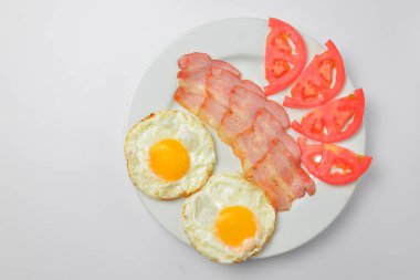 Köy usulü, lezzetli pastırma ve yumurta yakın plan. Geleneksel kahvaltı fikri. Kahvaltıda yumurtalı ekmek. Beyaz arka planda izole edilmiş beyaz bir tabakta servis edilmiş. Boşluk afişini kopyala.