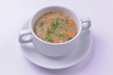 Beyaz arka planda servis edilen bir kase geleneksel tavuk çorbası resmi. Akşam yemeği için tavuk suyu çorbası. Lezzetli sağlıklı yemek..