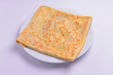 İçinde peynirli krep var. Beyaz tabakta servis edilmiş. Akşam yemeği için lezzetli bir yemek. Boşluk afişini kopyala,