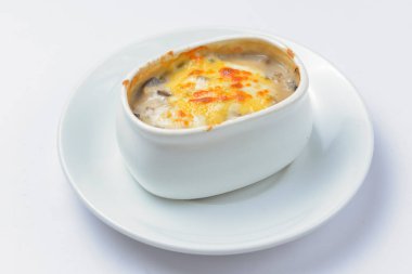 Kavrulmuş sebze, patates, mantar ve peynir bir tencerede. Beyaz bir tencerede yemek pişirdim. Akşam yemeği için lezzetli bir yemek. Beyaz arkaplanda servis edildi.