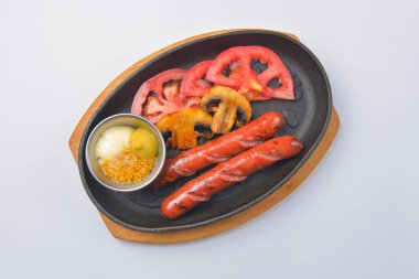 Izgara ızgara sosis ve hardal soslu mantar. Fast food konsepti. Akşam yemeği için lezzetli bir yemek. Beyaz arkaplan.
