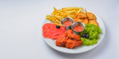 Domates soslu tavuk kanadı. Beyaz arka planda beyaz bir tabakta servis edilmiş. Kapatın. Fast food, abur cubur kavramı.