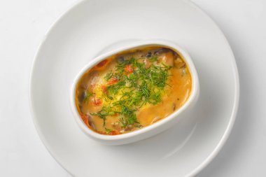 Kavrulmuş sebze, patates, mantar ve peynir bir tencerede. Beyaz bir tencerede yemek pişirdim. Akşam yemeği için lezzetli bir yemek. Beyaz arkaplanda servis edildi.