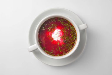 Ukrayna pancar çorbası - ekşi kremalı borş beyaz arka planda beyaz bir kasede servis edilir. Geleneksel Ukrayna mutfağı kavramı, beyaza izole edilmiş, yakın çekim.