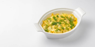 Beyaz arka planda beyaz bir tencerede servis edilen taze yeşillikli Ravioli köftesi. Beyazda izole edilmiş. Geleneksel İtalyan mutfağı.