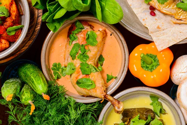 Traditional Georgian cuisine Top View. Okroshka with Matzoon and Coriander, Salmon Steak with Nut Sauce, Grilled Mackerel, Khash Chikhirtma Harcho Soup, Dolma, Chanakhi, Chashululi, Chkmeruli, Kupati. — Stock Image Traditional Georgian Cuisine Top View Okroshka Matzoon Coriander Salmon Steak Stock Photo