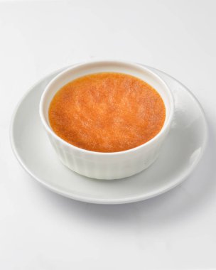 Beyaz arka planda beyaz bir tabakta Brulee kreması. Beyaz üzerine izole edilmiş lezzetli geleneksel Fransız tatlısı. Fransız mutfağı kavramı.
