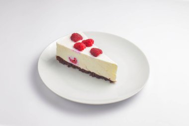 Taze çilekli cheesecake, üzerinde böğürtlen olan New York cheesecake beyaz arka planda beyaz bir tabakta servis edilir. Peynirli kek beyazda izole edilmiş. Çay saati için lezzetli tatlı..