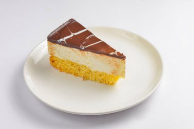 Beyaz arka planda bir parça vanilyalı ve çikolatalı kek. Çay saatinde tatlı tatlı tatlı tatlı.