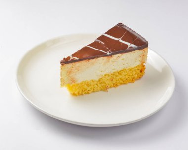 Beyaz arka planda bir parça vanilyalı ve çikolatalı kek. Çay saatinde tatlı tatlı tatlı tatlı.