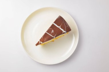 Beyaz arka planda bir parça vanilyalı ve çikolatalı kek. Çay saatinde tatlı tatlı tatlı tatlı.