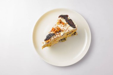 Beyaz arka planda beyaz bir tabakta servis edilen bir dilim erikli ballı kek. Beyazda izole edilmiş. Çay ya da kahve için lezzetli tatlı..