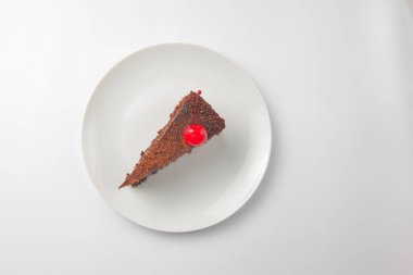 Beyaz tabakta çikolatalı pasta. Beyaz arka planda servis edilen bir parça yumuşak kremalı çikolatalı pasta. Beyazda izole edilmiş. Çay ya da kahve için lezzetli tatlı..