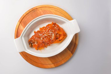 Fırınlanmış sebze güveci ve balık. Beyaz arka planda beyaz bir tencerede hizmet vermiş. Lezzetli mevsimlik akşam yemeği, sonbahar yemeği.